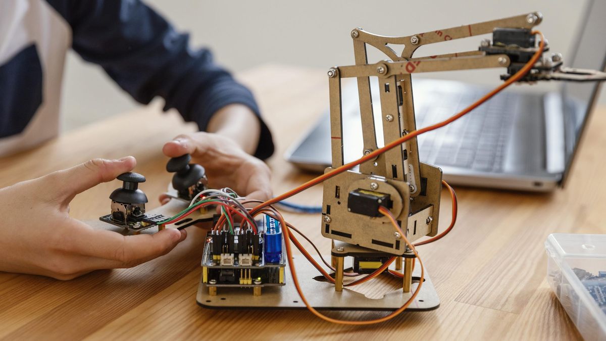 Estudiante programando un brazo robótico